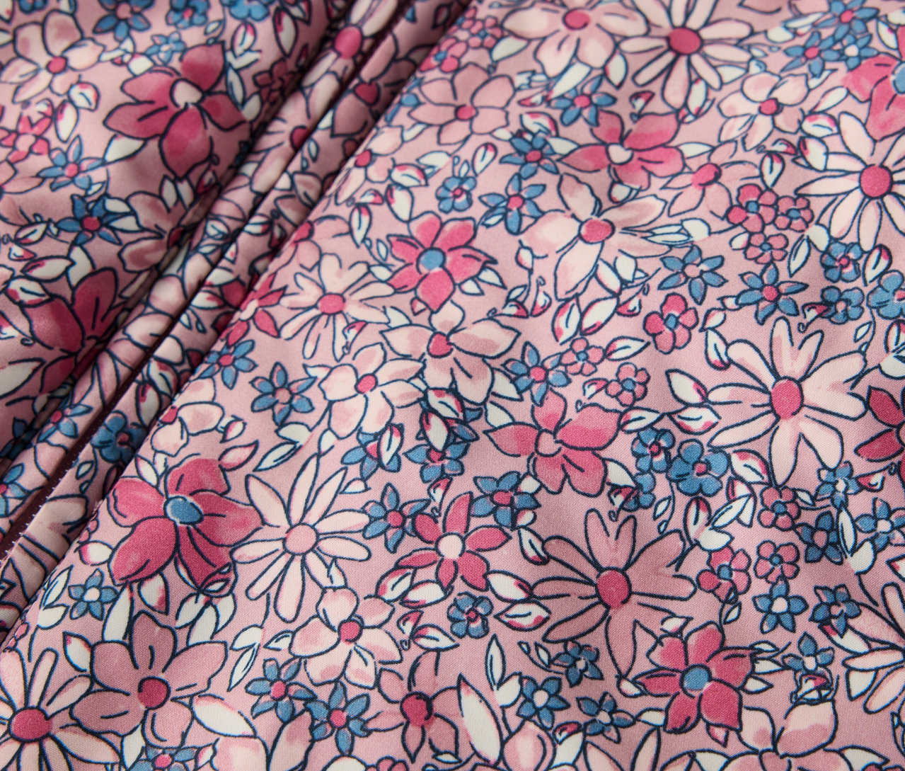 Detailný záber na detský zimný overal s kvetinovým vzorom.