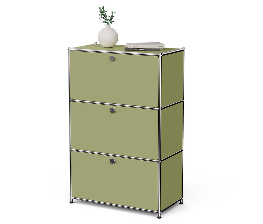 Zelená skrinka s tromi zásuvkami, na ktorej stojí váza s rastlinou a kniha.