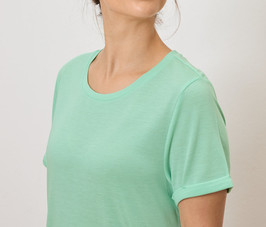 Žena má na sebe svetlozelené tričko.