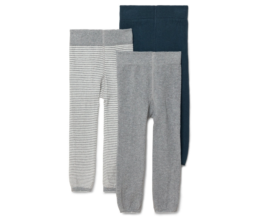 Tri detské pančuchy v šedej farbe s bielymi prúžkami, šedej a tmavomodrej ležia vedľa seba.