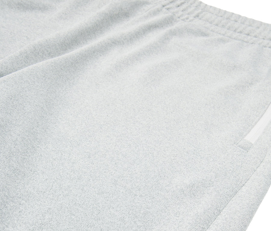 Detail šedých šortiek Fila s rozparkom na leme.