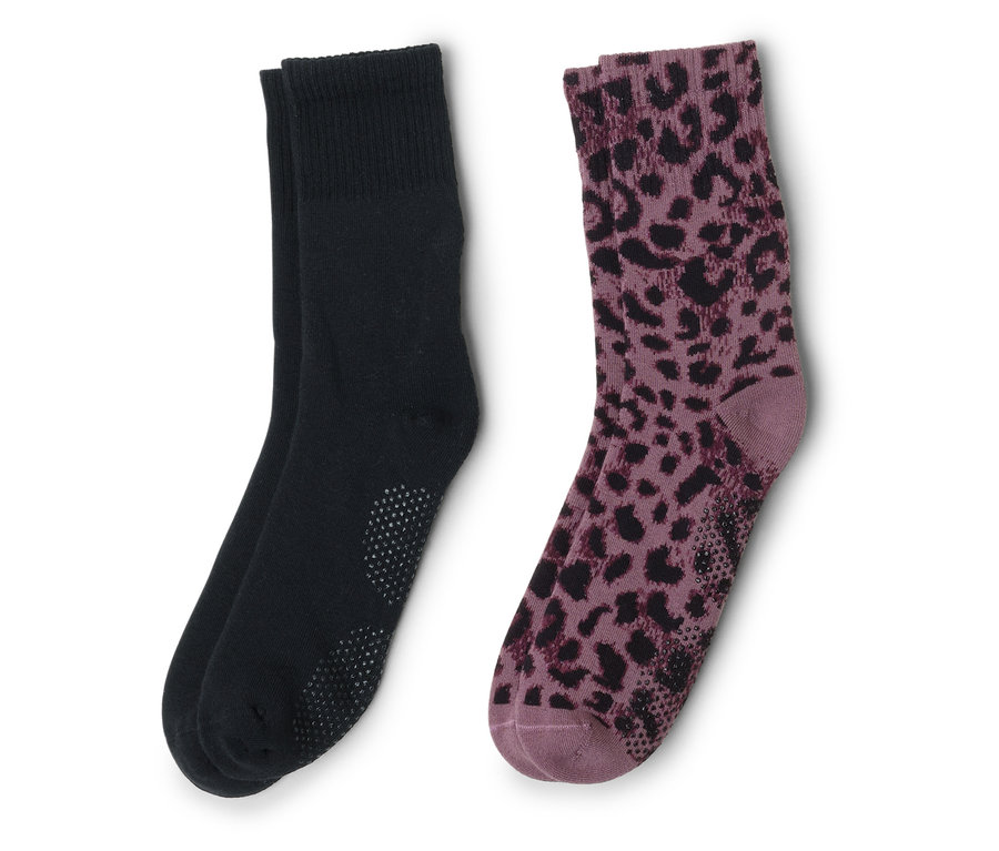 Dve ponožky ležia vedľa seba, jedna čierna s výstupkami, druhá fialová s čiernym leopardím vzorom.