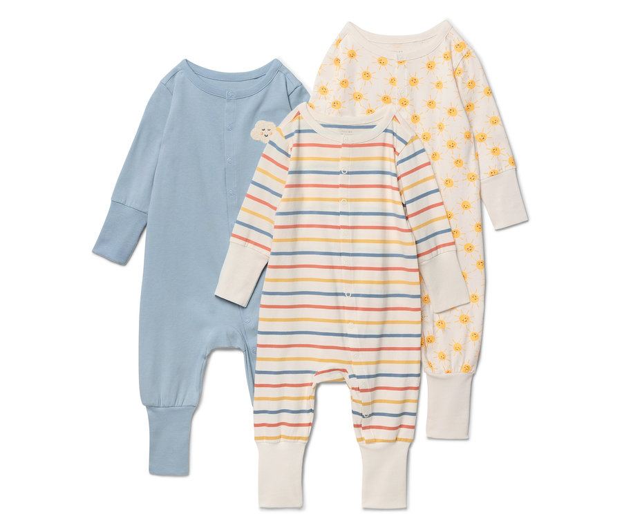 Tričko pre bábätká ležia na bielom pozadí. Ľavé tričko je modré s malým oblakom na hrudi. Stredné tričko je pruhované v béžovej, žltej, červenej a modrej farbe. Pravé tričko je krémovej farby so žltým slnečným vzorom.