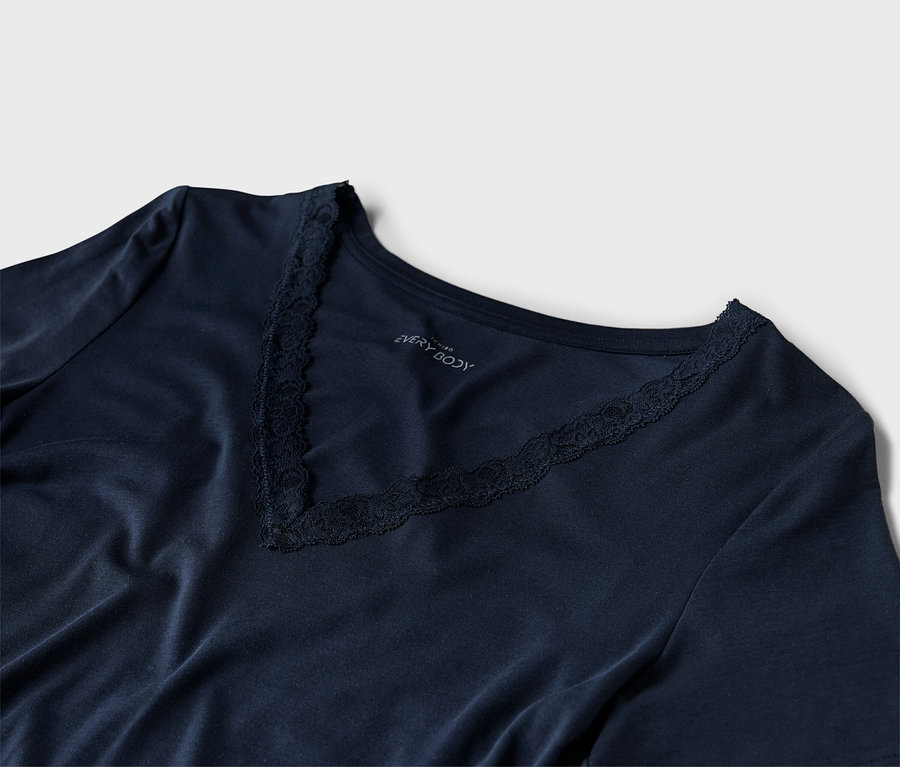 Detailný záber na tmavomodré tričko s véčkovým výstrihom a čipkovanými detailmi.