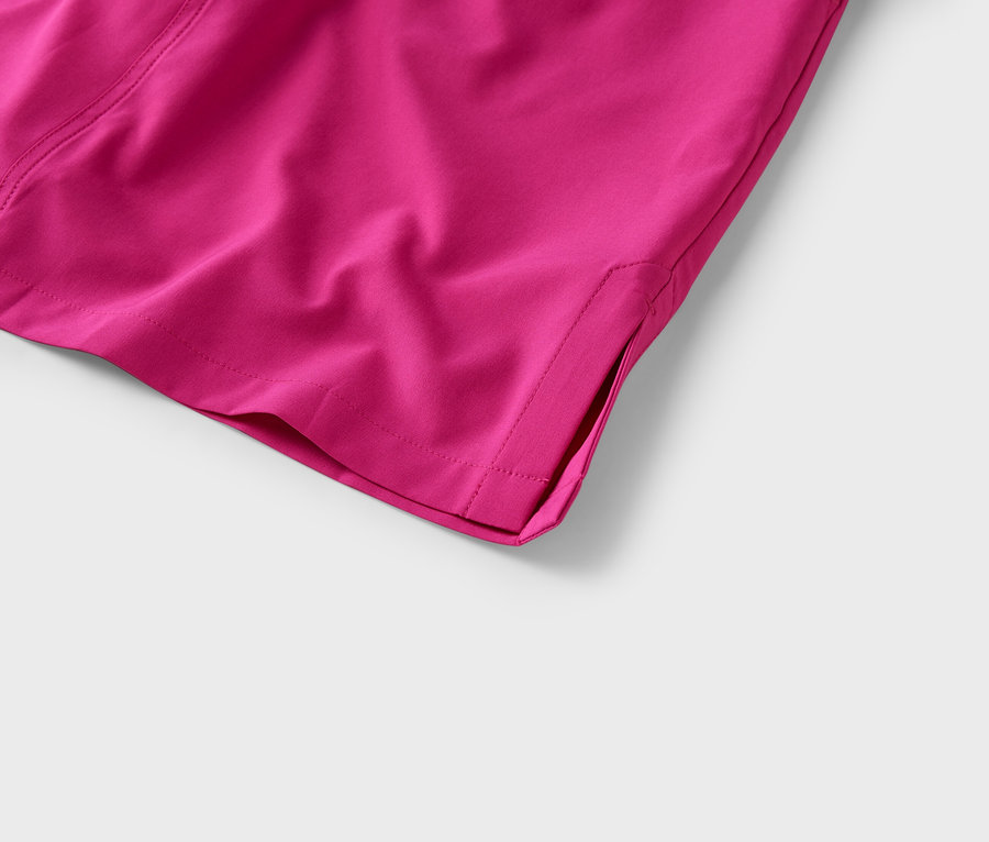 Detail rohu páru ružových látkových nohavíc s rozparkom na leme.