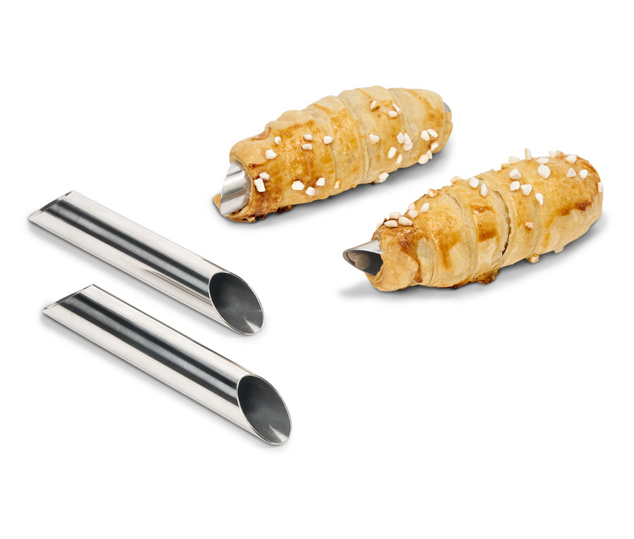 Dve rolky cesta plnené krémom ležia vedľa dvoch kovových foriem.