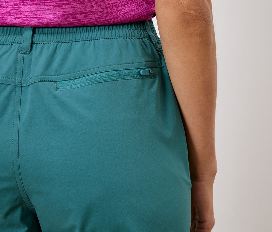 Detailný záber na zadnú časť tyrkysových nohavíc s elastickým pásom a vreckom na zips.