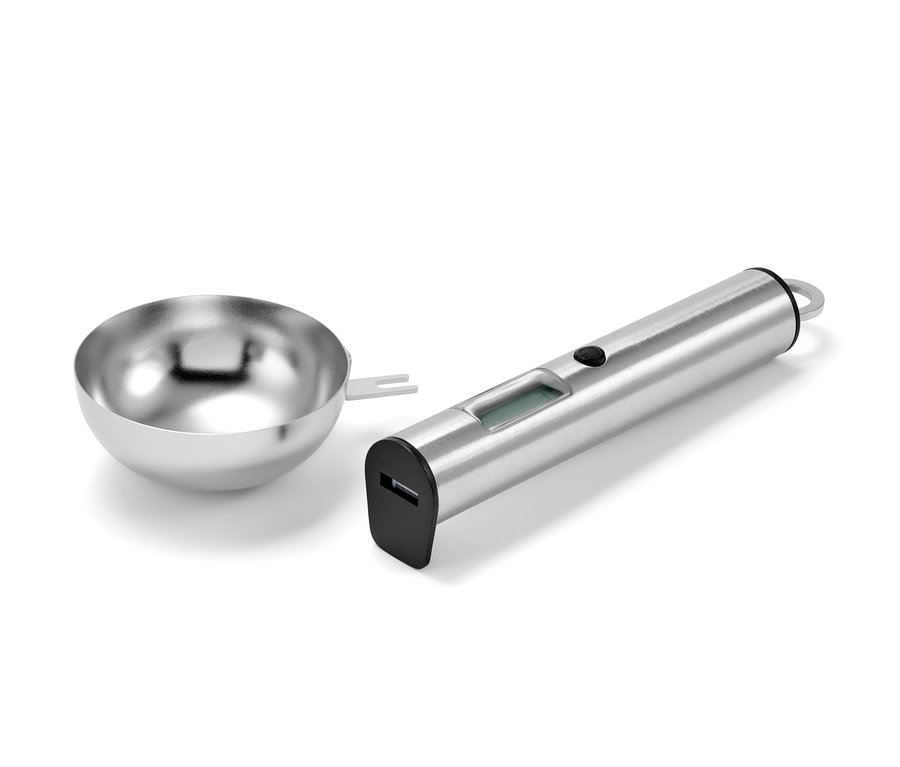 Digitálna kuchynská váha v tvare lyžičky z nehrdzavejúcej ocele vedľa nerezovej misky.