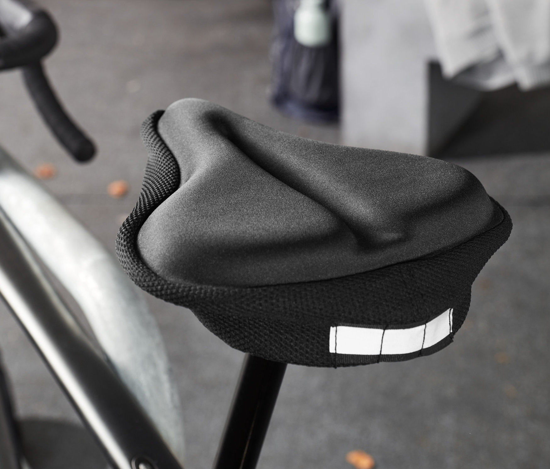 Detailný záber na čierny bicykel s čiernym poťahom na sedadlo s pamäťovou penou.