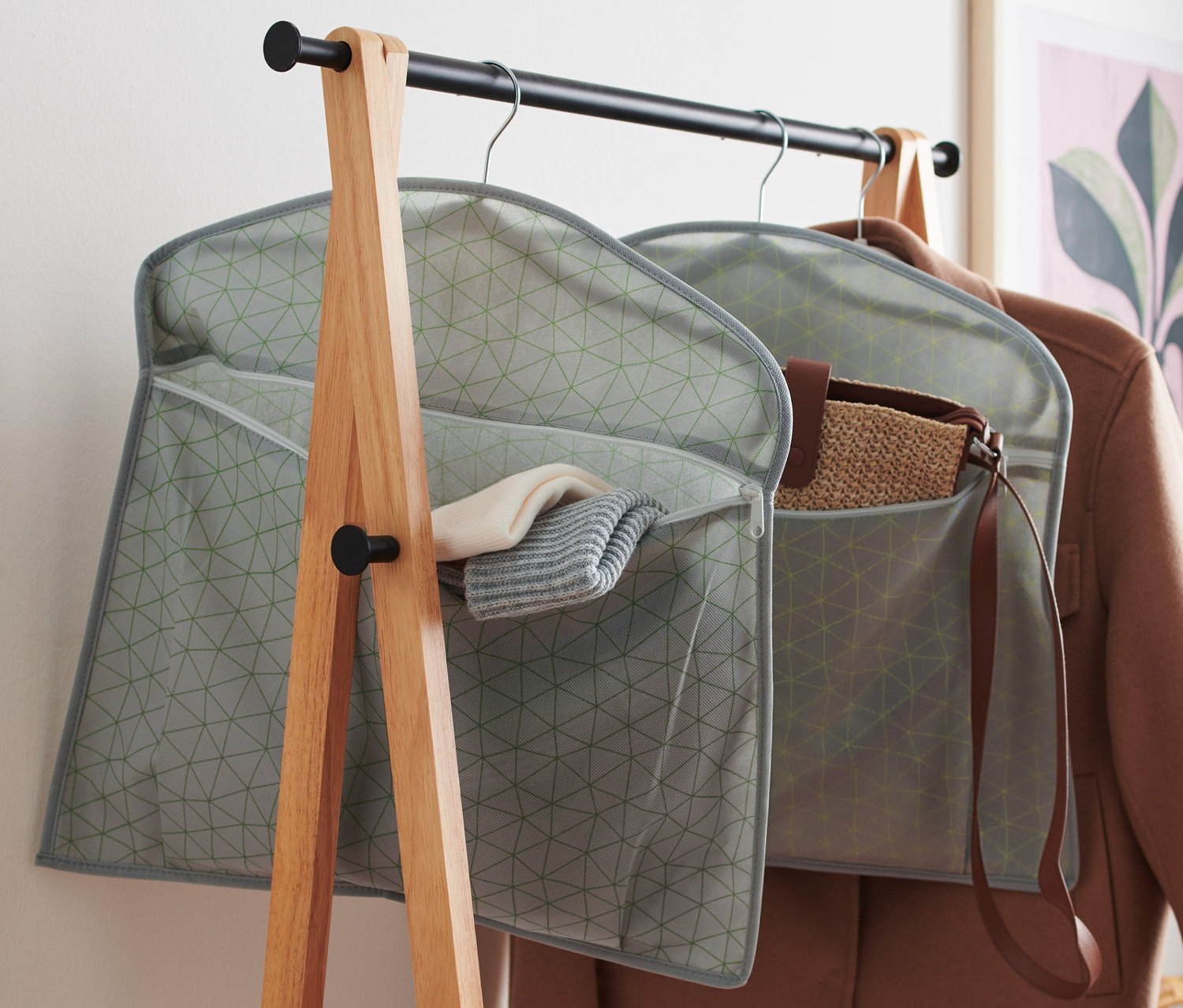 Dva sivé organizéry do skrine visia na vešiakoch na vešiaku.