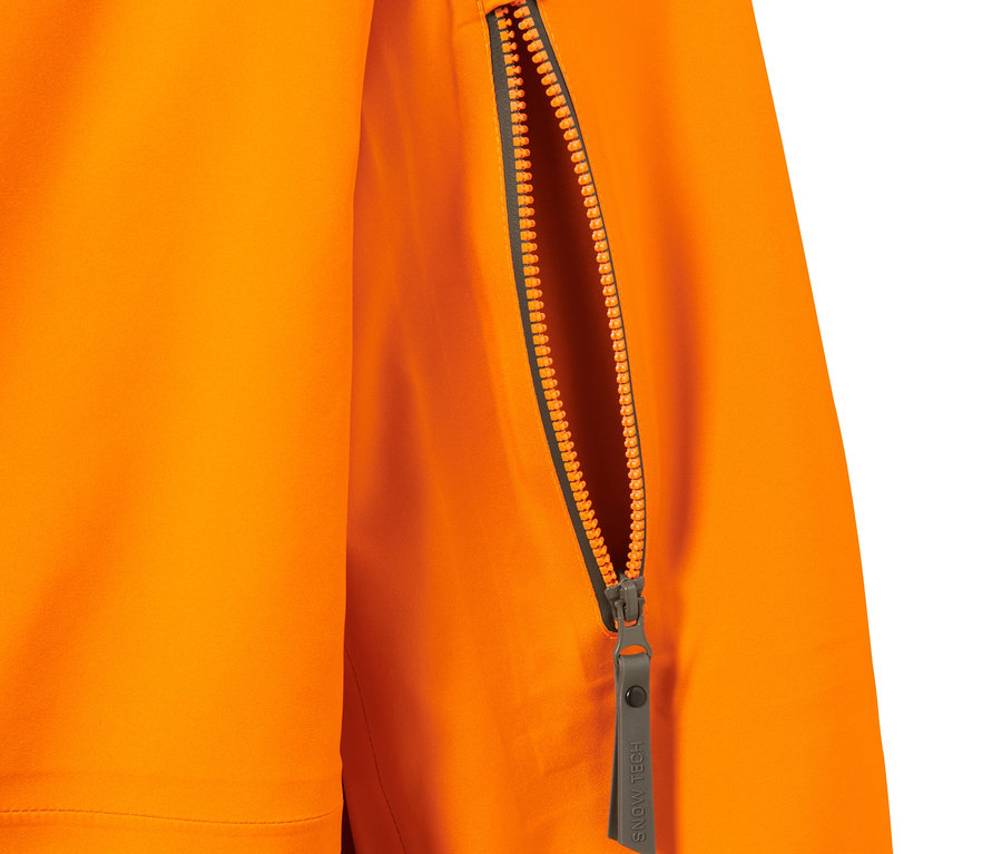 Detail oranžovej hardshellovej lyžiarskej bundy so zipsom na vrecku.