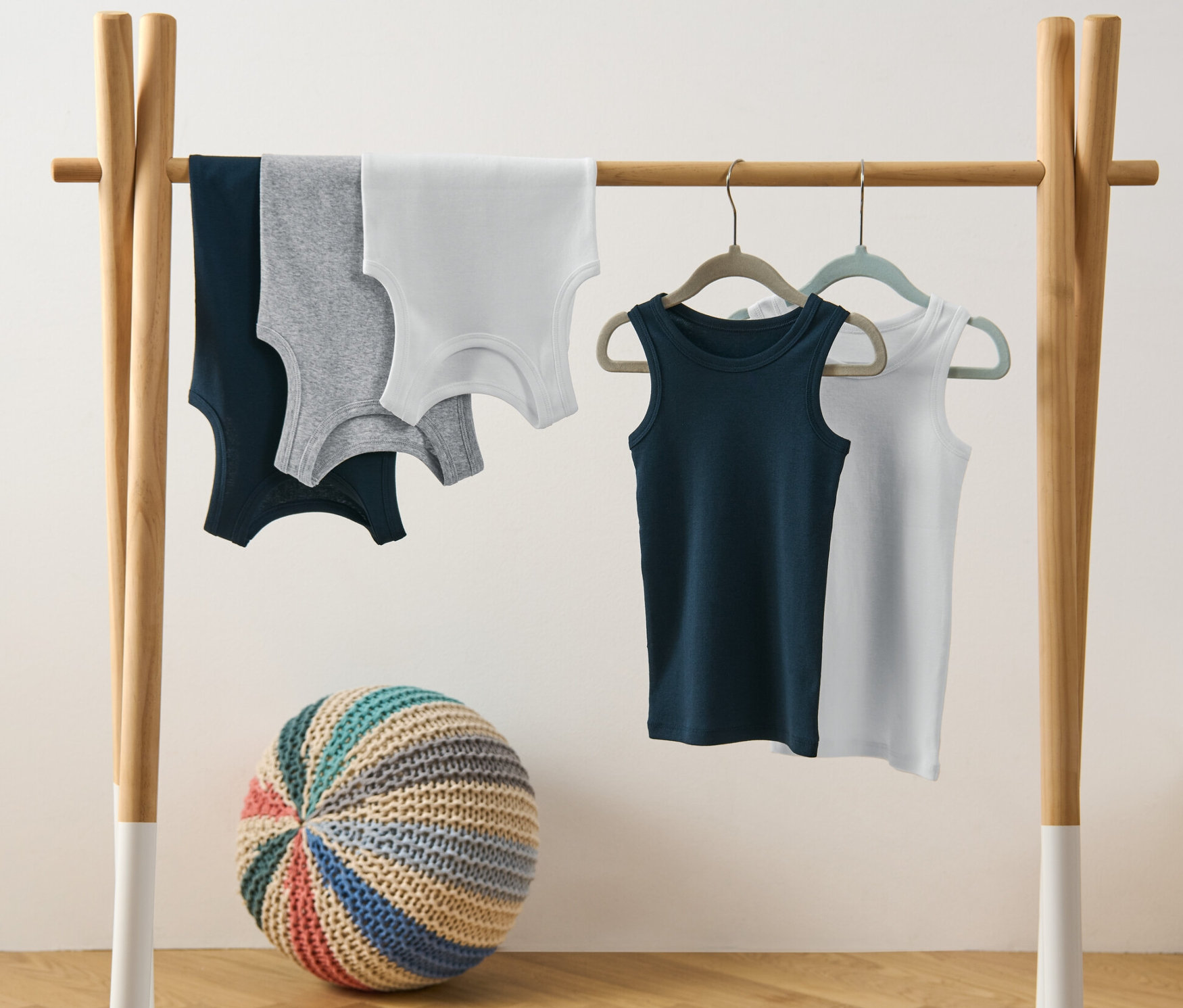 Päť chlapčenských tielok visí na vešiaku.