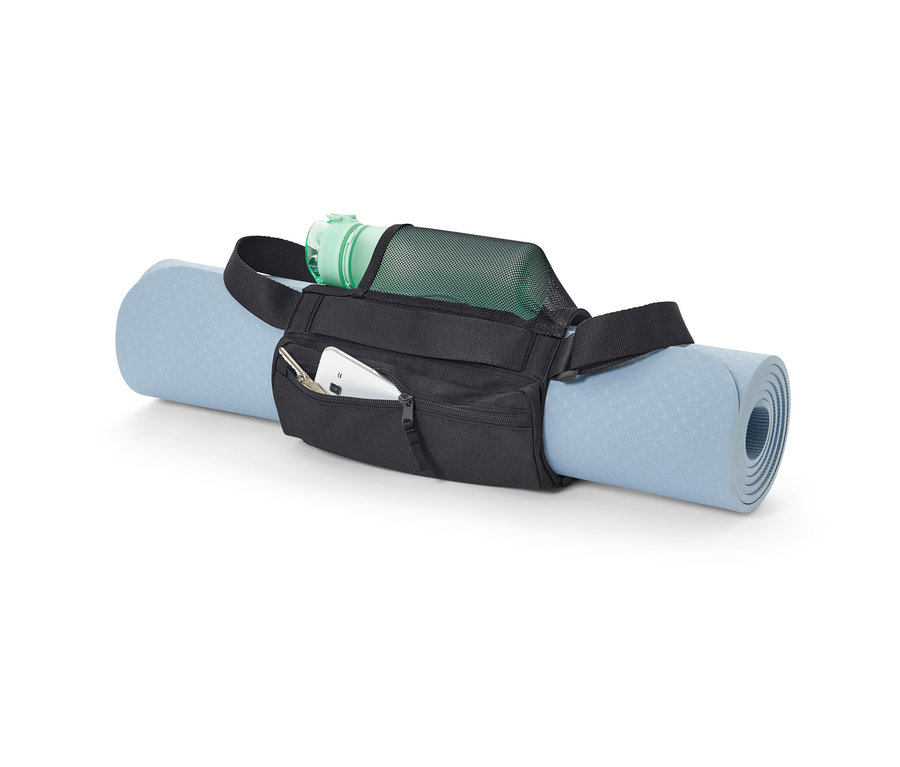 Modrá podložka na cvičenie je pripevnená čiernym popruhom na nosenie podložky. Vo vrecku popruhu je mobilný telefón a kľúče a v sieťovom vrecku je zelená fľaša s vodou.