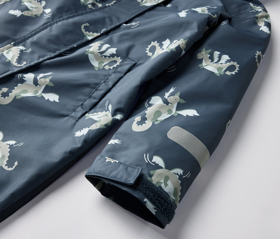 Detail detského overalu do dažďa s motívom rytiera, s vreckom a reflexným prvkom.