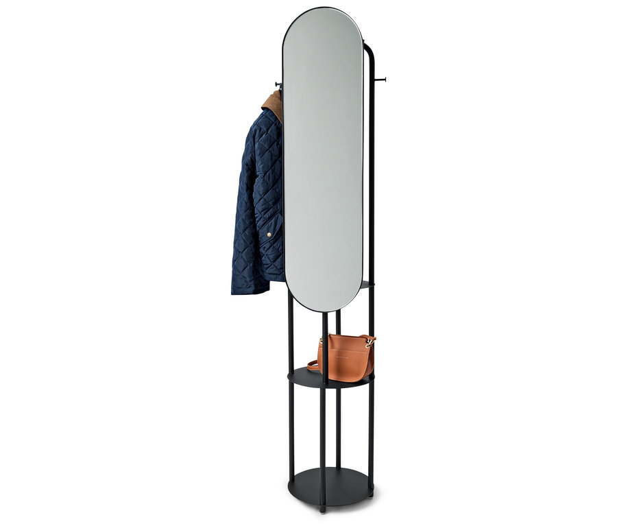 Čierny stojan s oválnym zrkadlom, modrá bunda a hnedá kabelka.