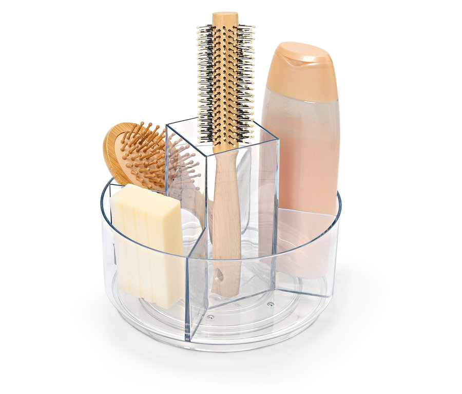 Priehľadná otočná nádoba s mydlom, kefou na vlasy a fľašou šampónu.