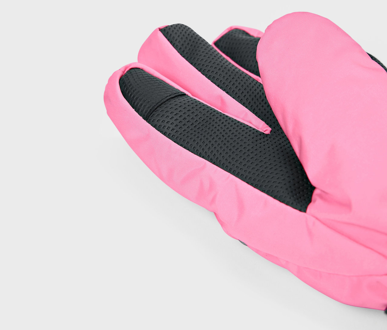 Detail ružovej rukavice s čiernou textúrou dlane.