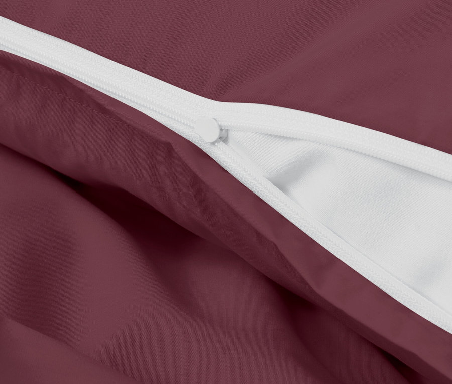 Detail bordového obliečky s bielym zipsom.