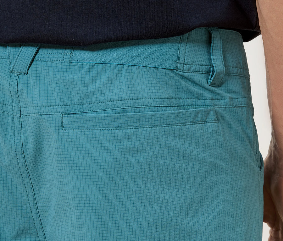 Detailný záber na zadnú časť tyrkysových nohavíc s vreckami.