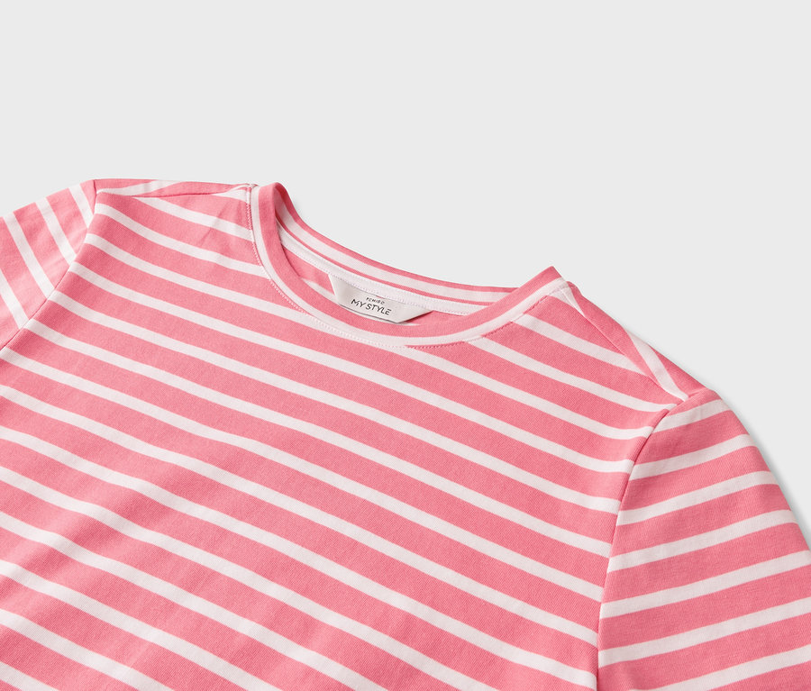 Detail ružovo-bieleho trička s horizontálnymi pruhmi.