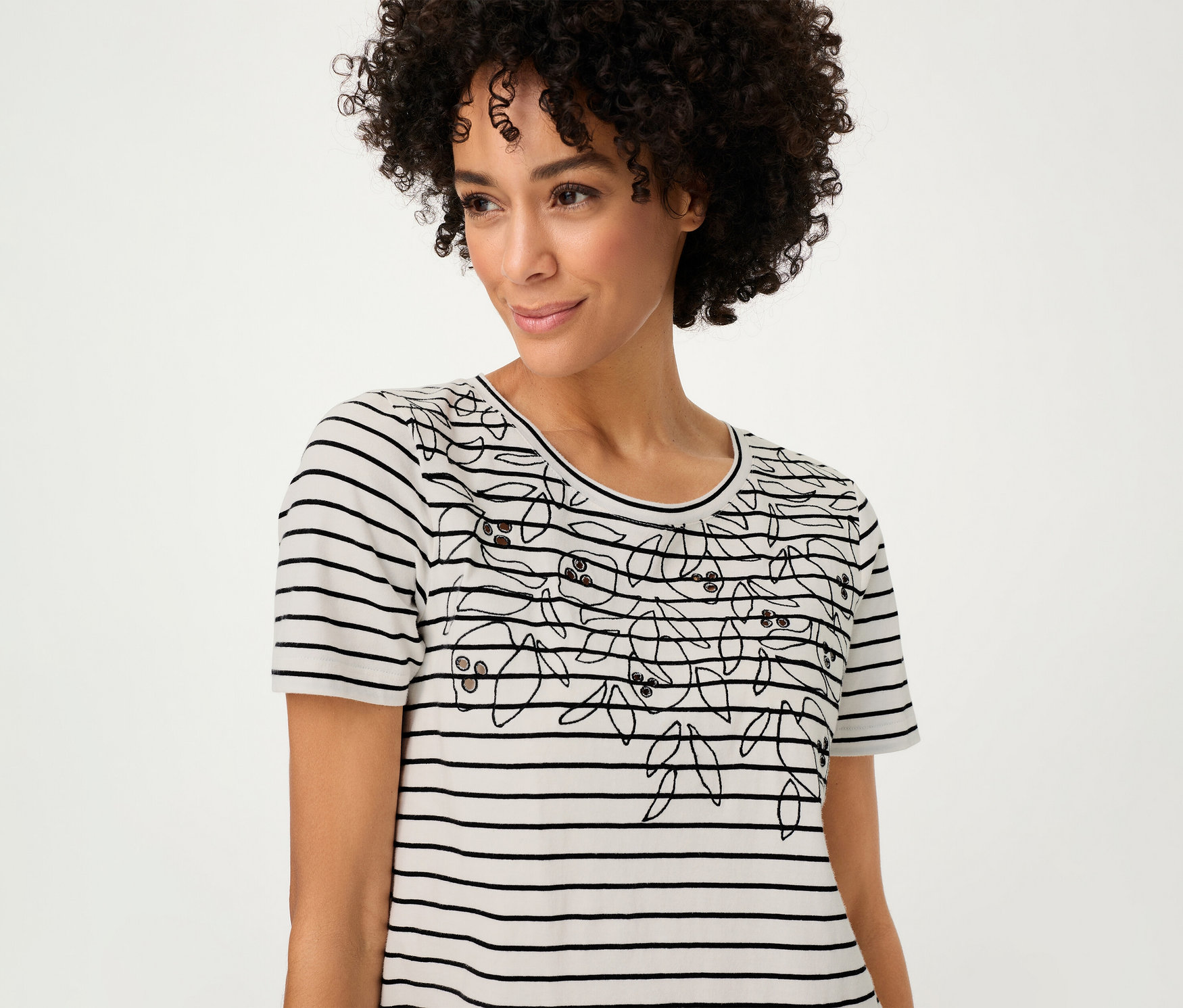 Žena má na sebe tričko Olsen s pruhovaným kvetinovým vzorom.