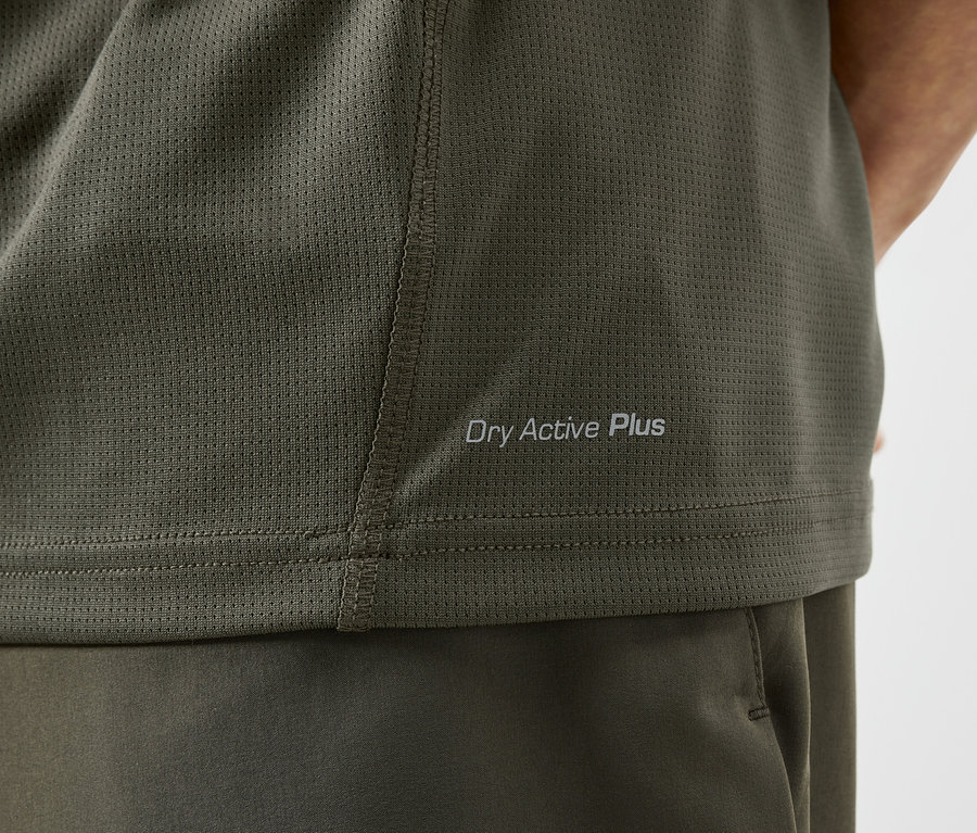 Detail olivového športového trička s nápisom "Dry Active Plus".
