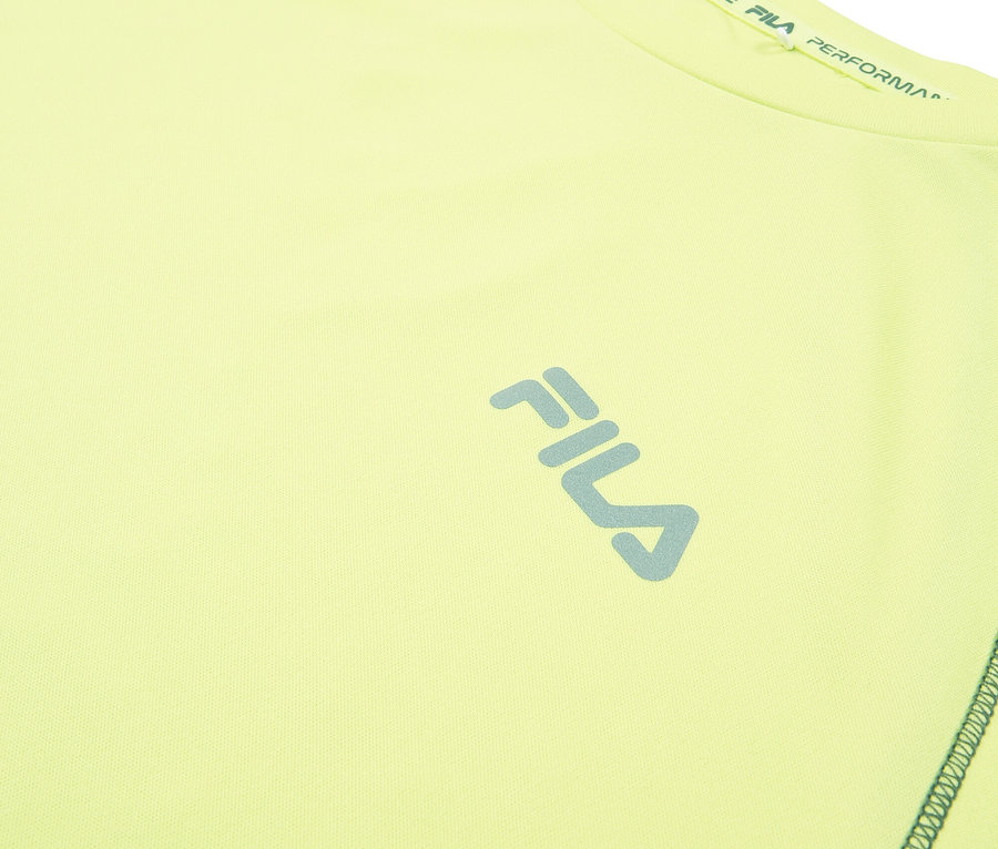 Detailný záber na svetložltý športový top Fila s modrým logom Fila.