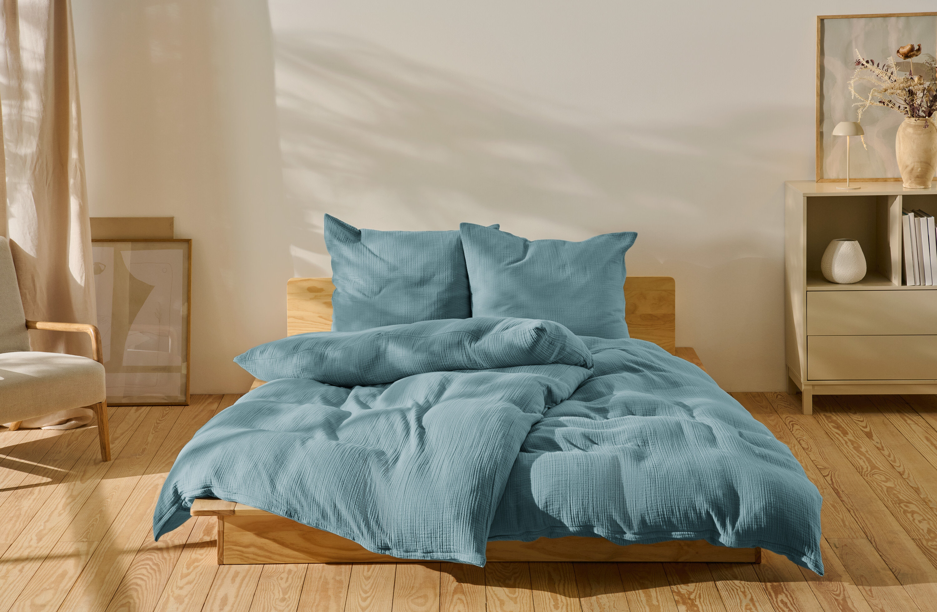 Modrá mušelínová posteľná bielizeň štandardnej veľkosti a nadmernej veľkosti na posteli.