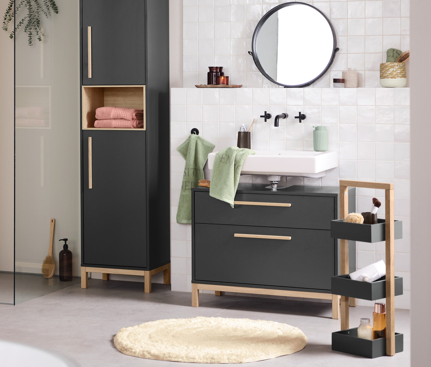 Interiér kúpeľne s umývadlom, zrkadlom a úložnými skrinkami Eklund v antracitovej farbe. V popredí je vaňa.