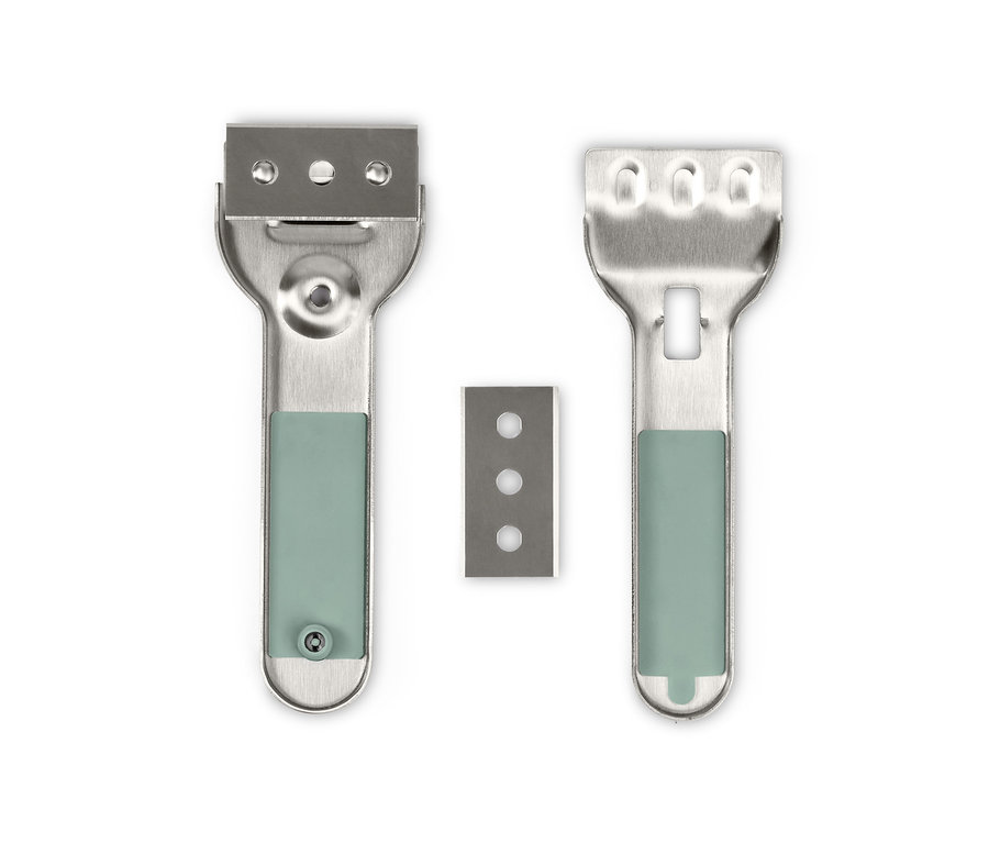 Dve strieborné čistiace škrabky a jedna náhradná čepeľ na bielom pozadí.