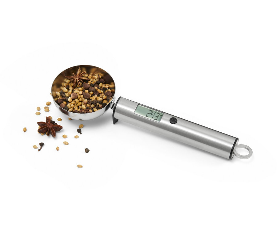 Digitálna kuchynská váha v tvare lyžičky plná korenia.