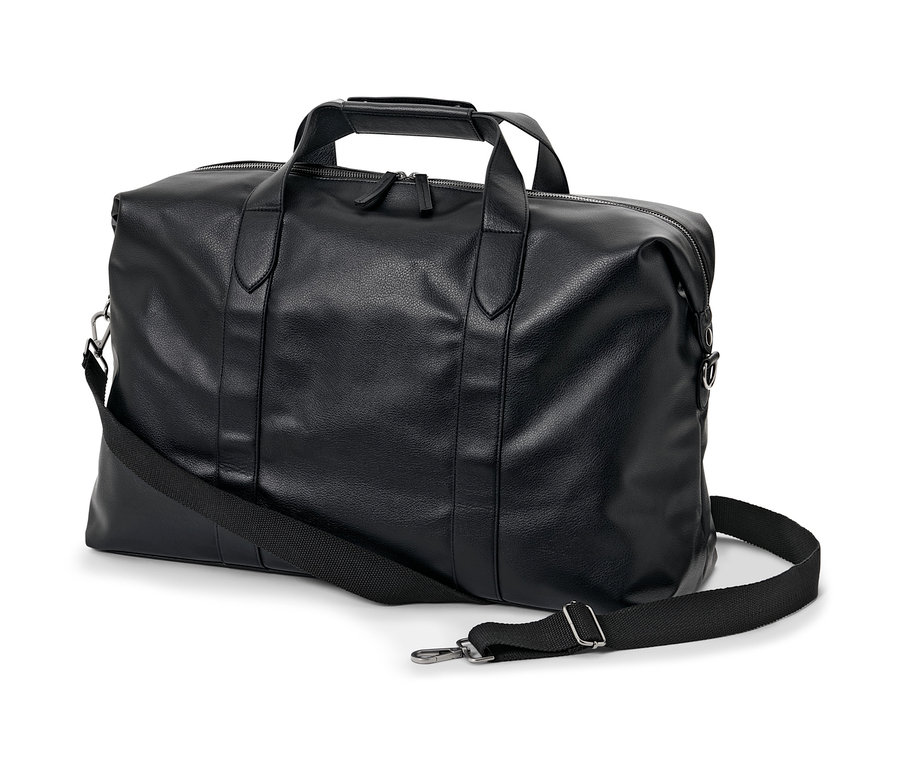 Čierna cestovná taška s popruhom cez rameno leží na bielom pozadí.