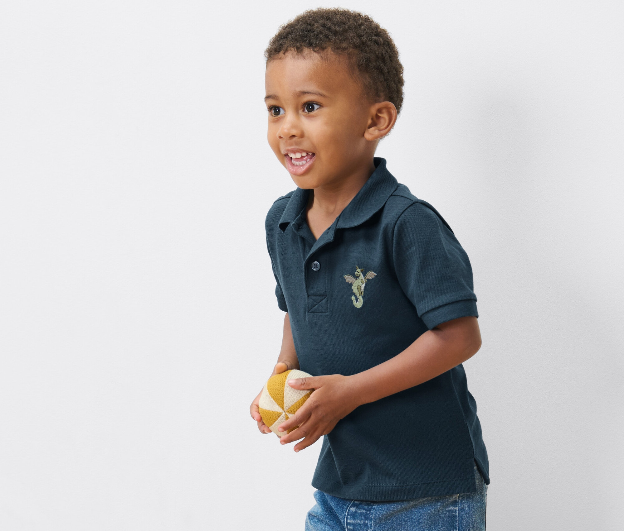 Chlapec v jednom z 2 detských polokošieľ z bavlneného piké drží loptu.