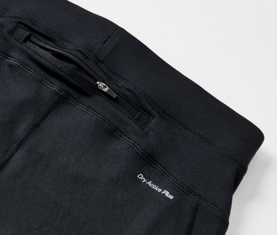Detail čiernych bežeckých legín s vreckom na zips a nápisom Dry Active Plus.