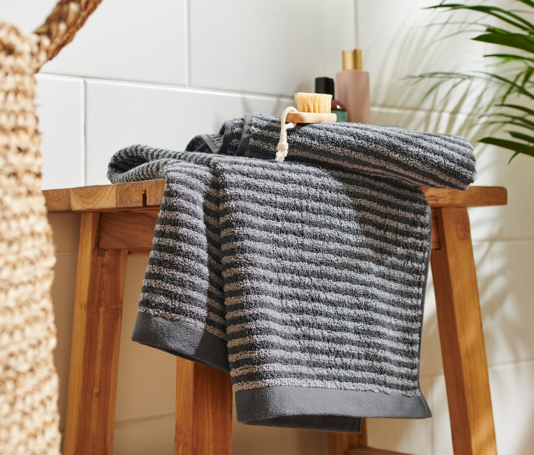 Na drevenej stoličke ležia dva kvalitné antracitové uteráky.