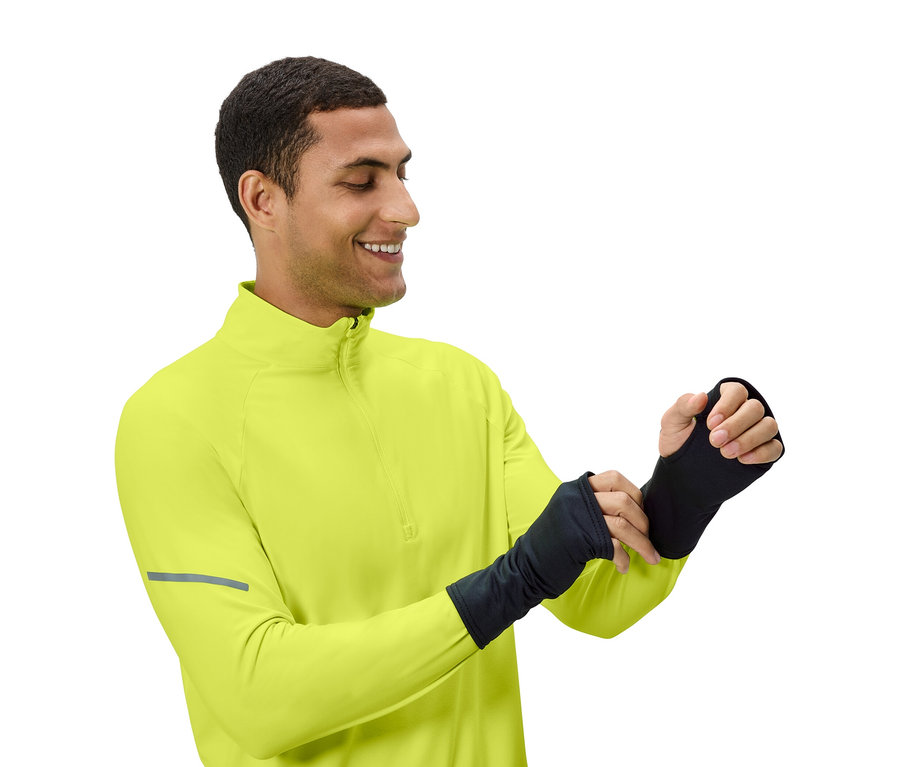 Muž si upravuje čierne návleky na ruky, má na sebe žltozelený top.