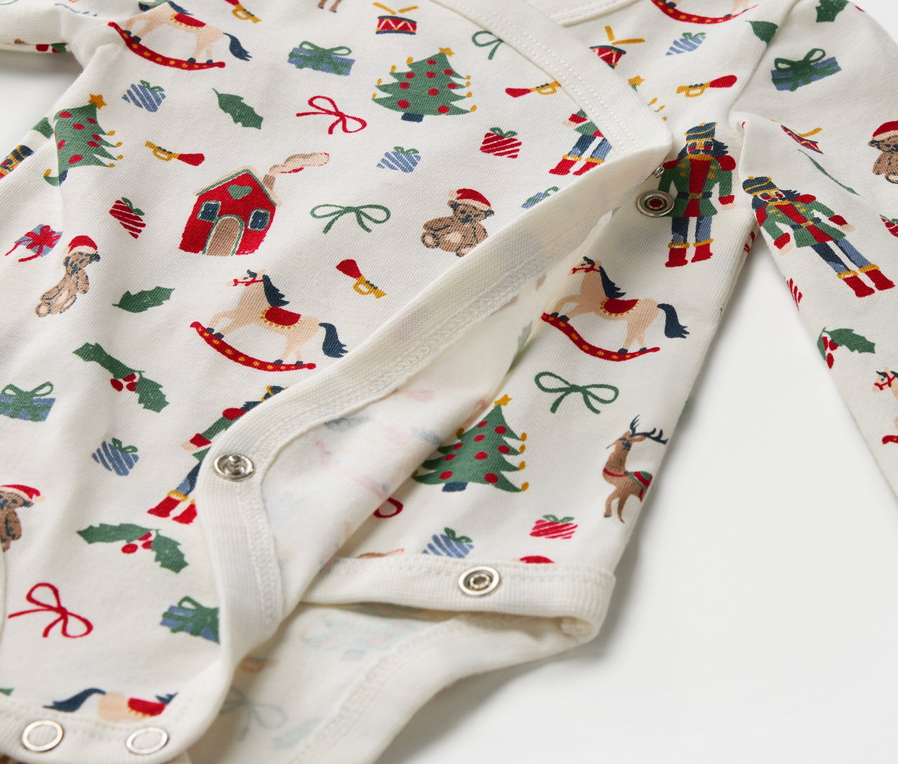 Detail bavlneného body s vianočnou potlačou, zapínanie na patentky.