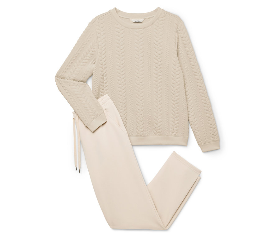 Béžová domáca súprava pozostávajúca zo svetra s vrkočovým vzorom a nohavíc so šnúrkou.
