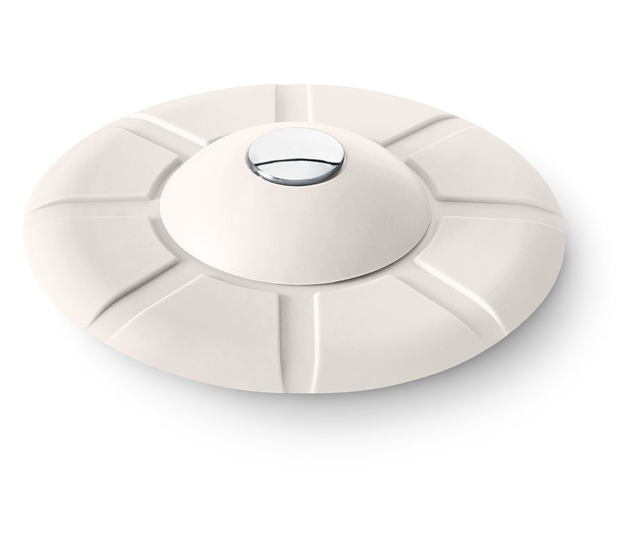 Krémový okrúhly predmet s konvexným vrchom a strieborným gombíkom v strede.