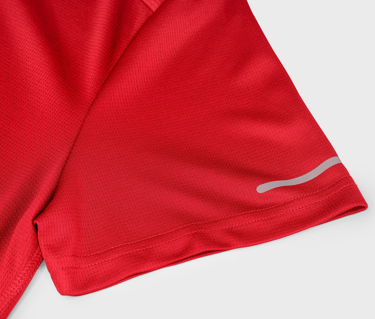 Detail červeného športového trička s krátkym rukávom a reflexným pruhom.