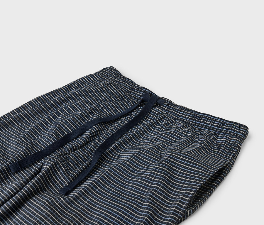 Detail modrých kockovaných nohavíc s elastickým pásom so sťahovacou šnúrkou.