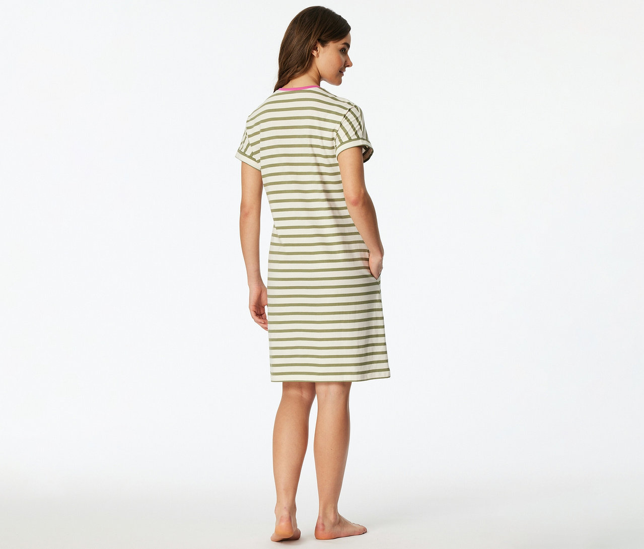 Žena stojí chrbtom k fotoaparátu a má na sebe pruhovanú nočnú košeľu SCHIESSER v béžovej a olivovozelenej farbe s ružovým výstrihom.