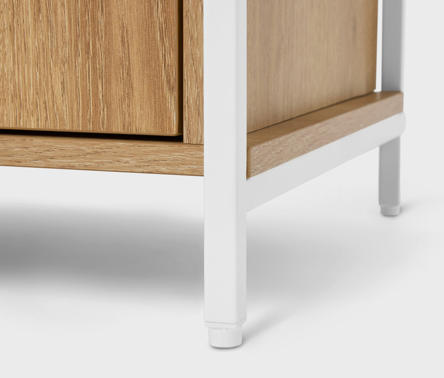 Detailný pohľad na drevenú skrinku s bielym kovovým rámom.