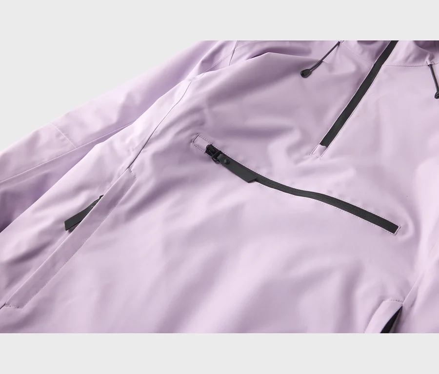 Detail fialovej bundy s čiernymi zipsami a šnúrkami. Horizontálny čierny zips je vľavo dole a diagonálny vpravo hore.