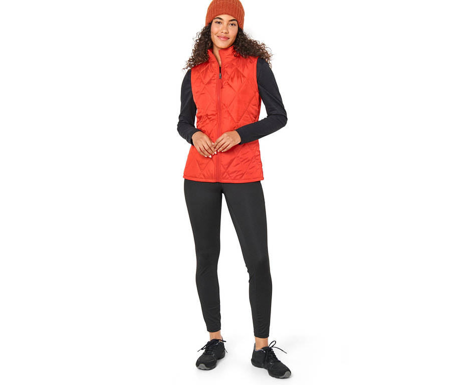 Žena má na sebe oranžovú vestu 3 v 1 a hnedú čiapku.