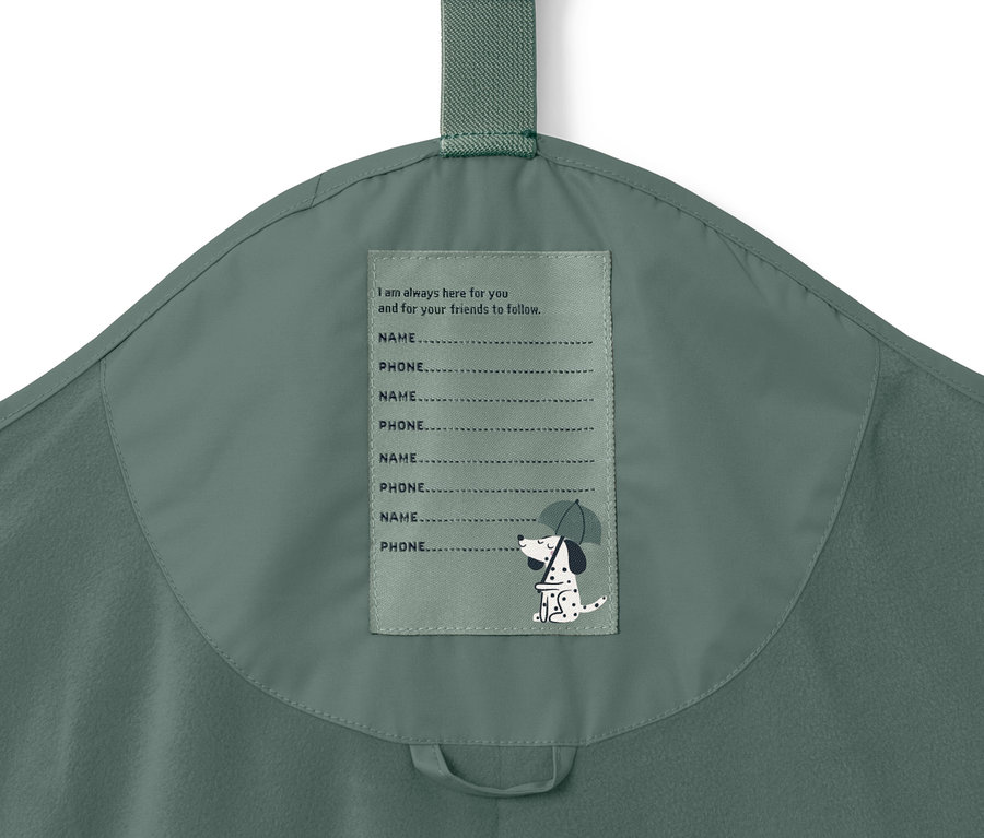 Detail detských termo nohavíc do dažďa, tmavozelené farby s štítkom pre meno a telefónne číslo.