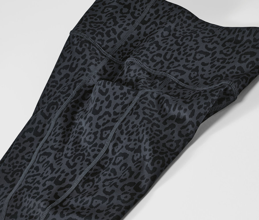 Detail sivých a čiernych športových legín so zvieracím vzorom.