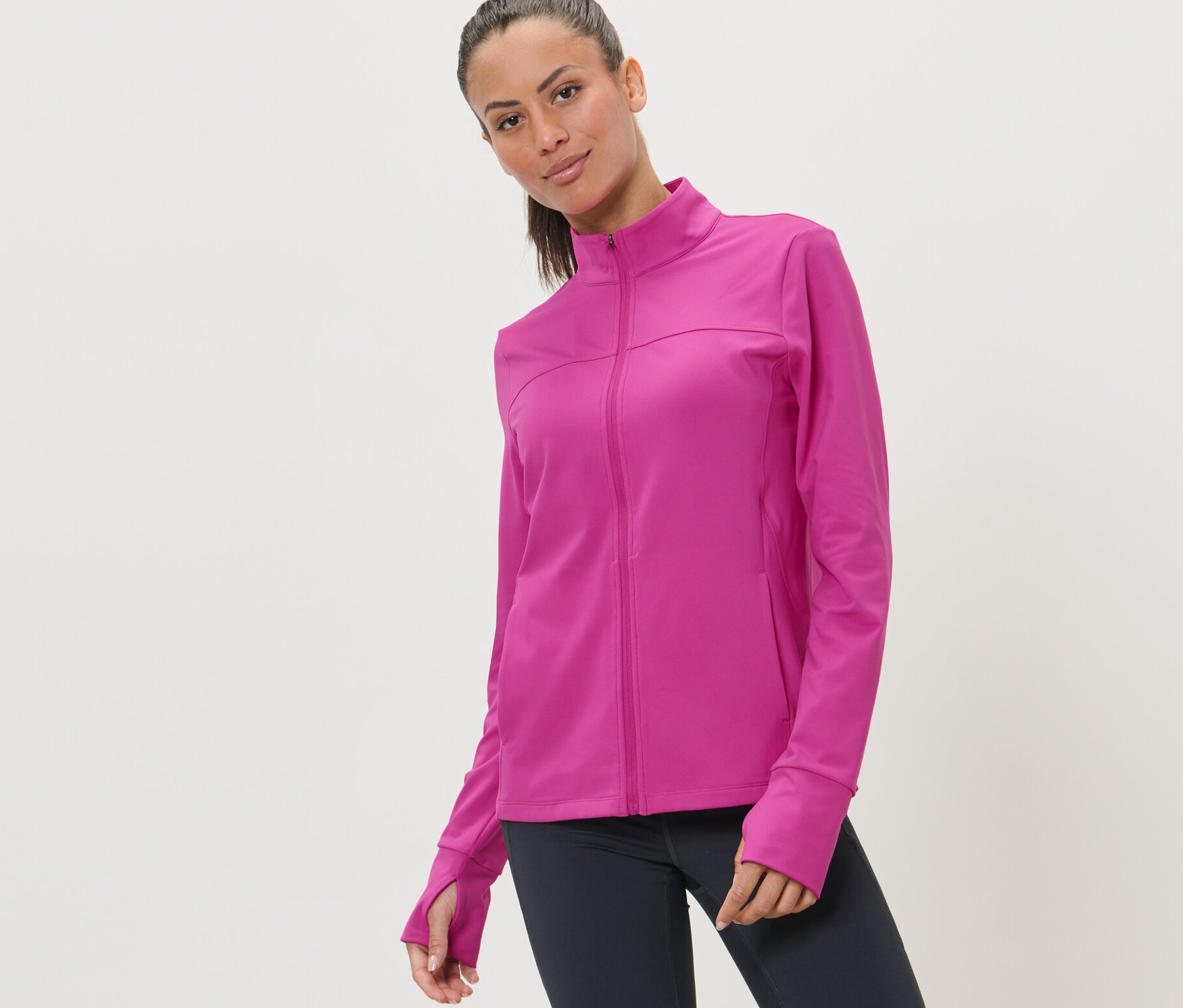 Žena má na sebe ružovú športovú bundu.