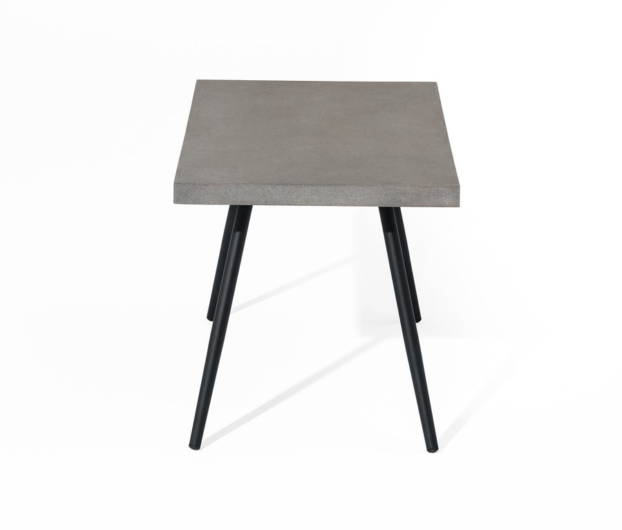 Konferenčný stolík s doskou z polycementu a čiernymi nohami.
