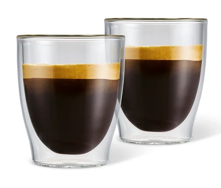 Dve dvojstenné poháre na caffè crema naplnené kávou.